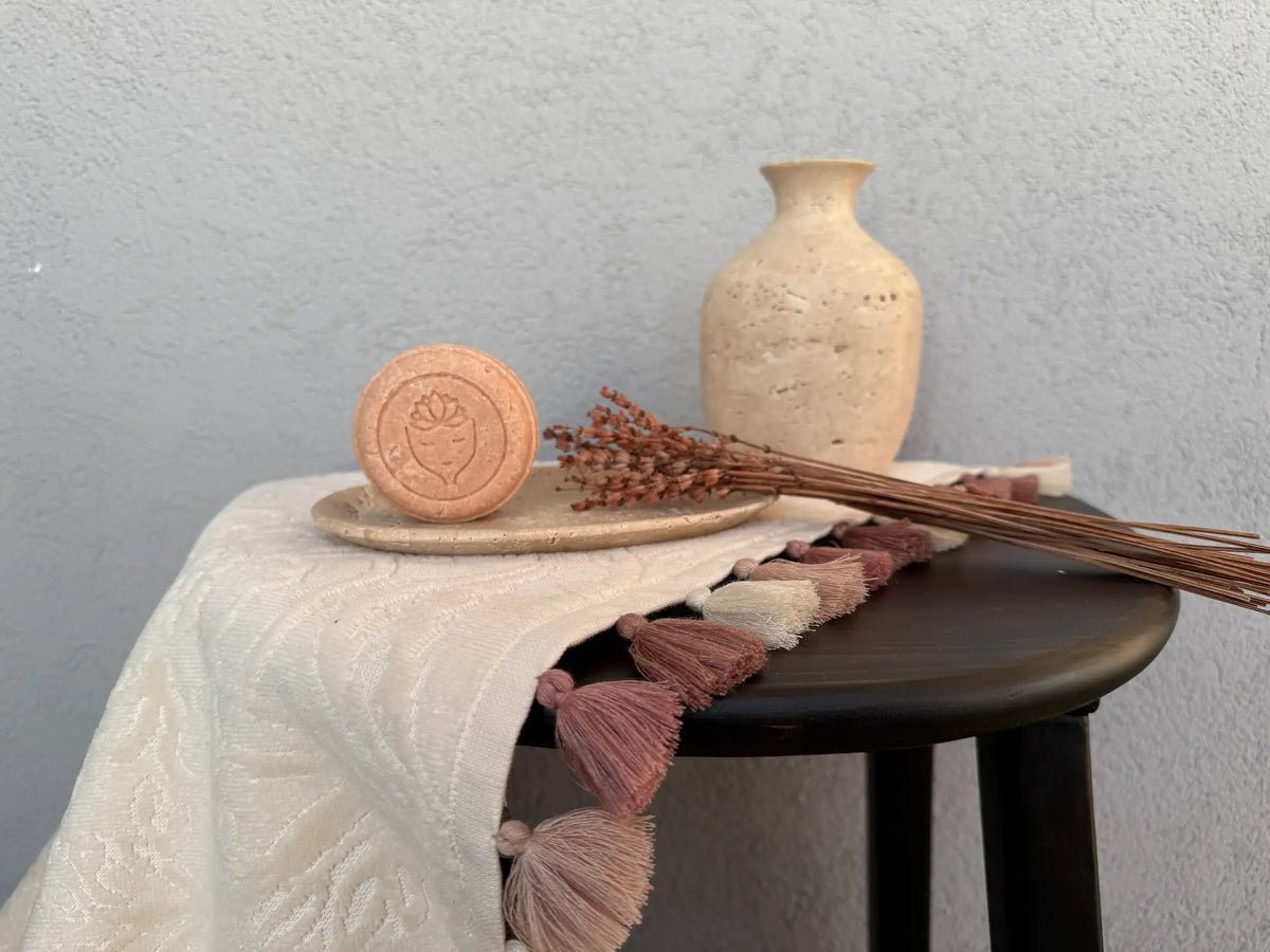 Pembe Alchebist katı şampuan, seramik tabakta kuru çiçeklerle